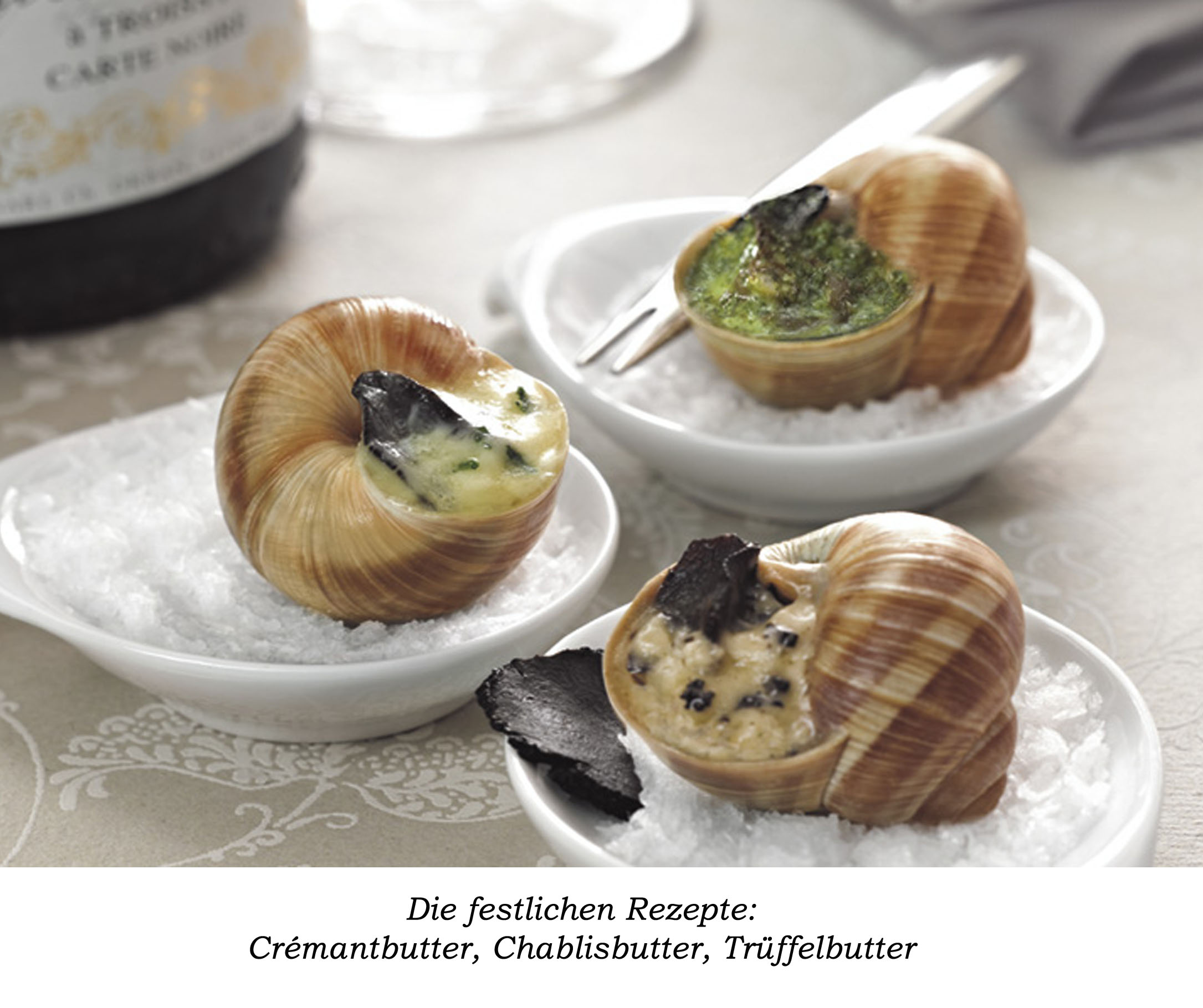 Drei kleine runde Teller mit jeweils einer Schnecke gefüllt mit Trüffelbutter, Chablisbutter und Crémantbutter