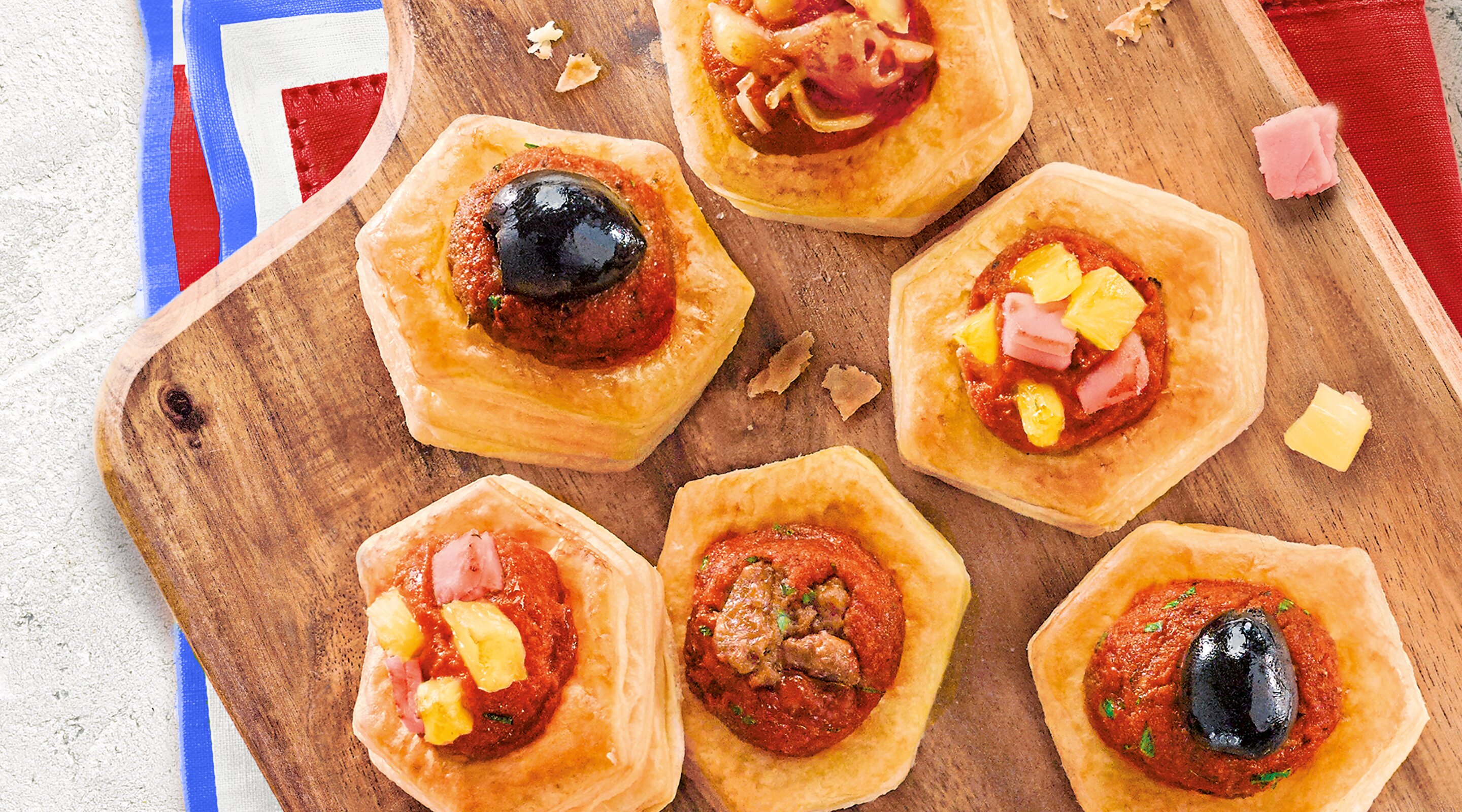 Some Italian snacks on a big wooden board with a French napkin